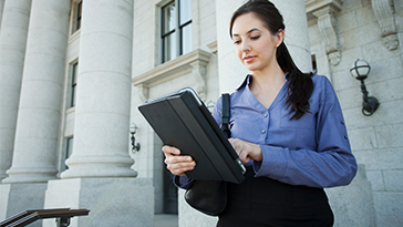 woman on tablet outside federal building