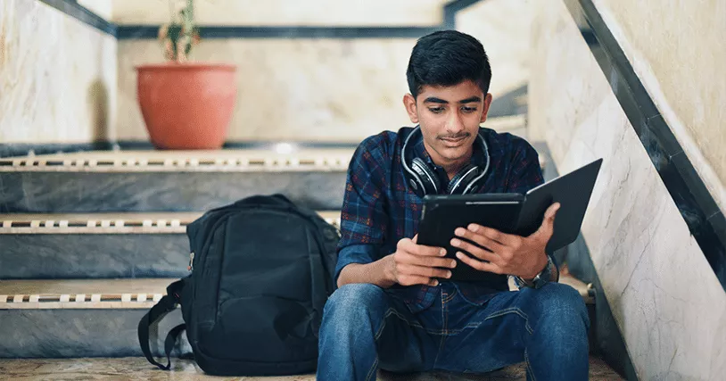 kid sitting on steps with tablet