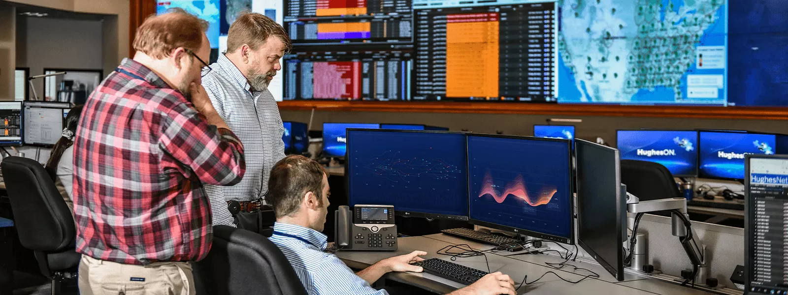 Employees looking at computer in ops center