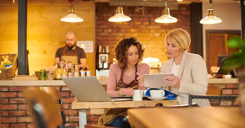 workers in restaurant looking at device screens