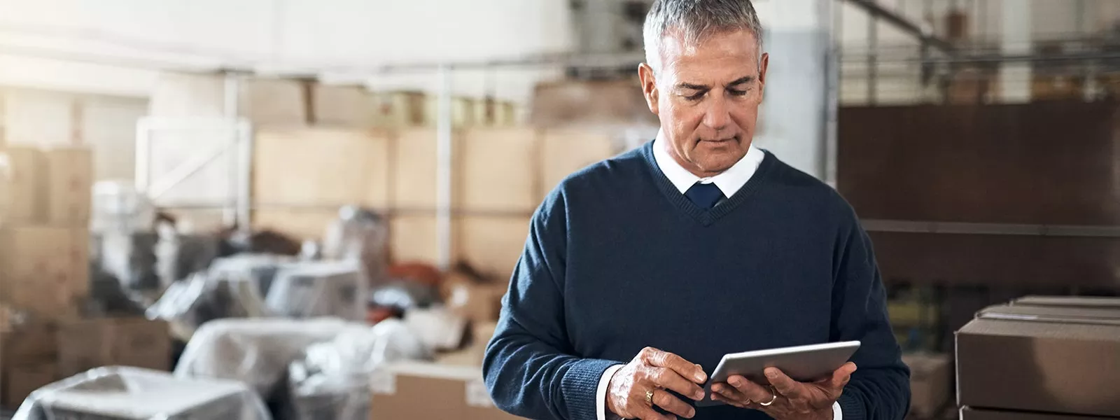 man in warehouse on tablet