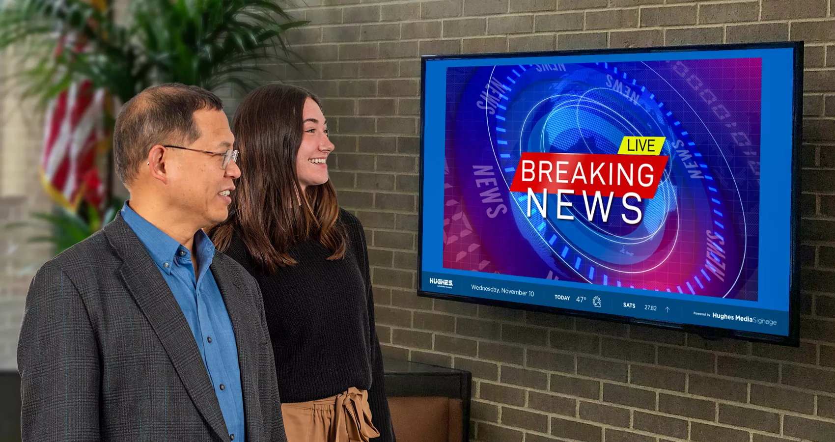 two employees looking at a tv screen